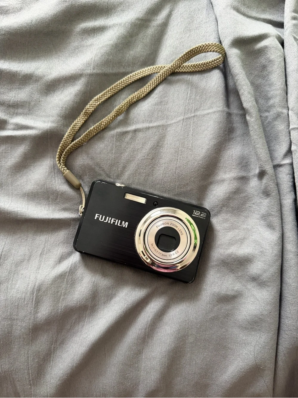 Fujifilm Black Camera with Silver Lens Ring and Beige Wrist Strap